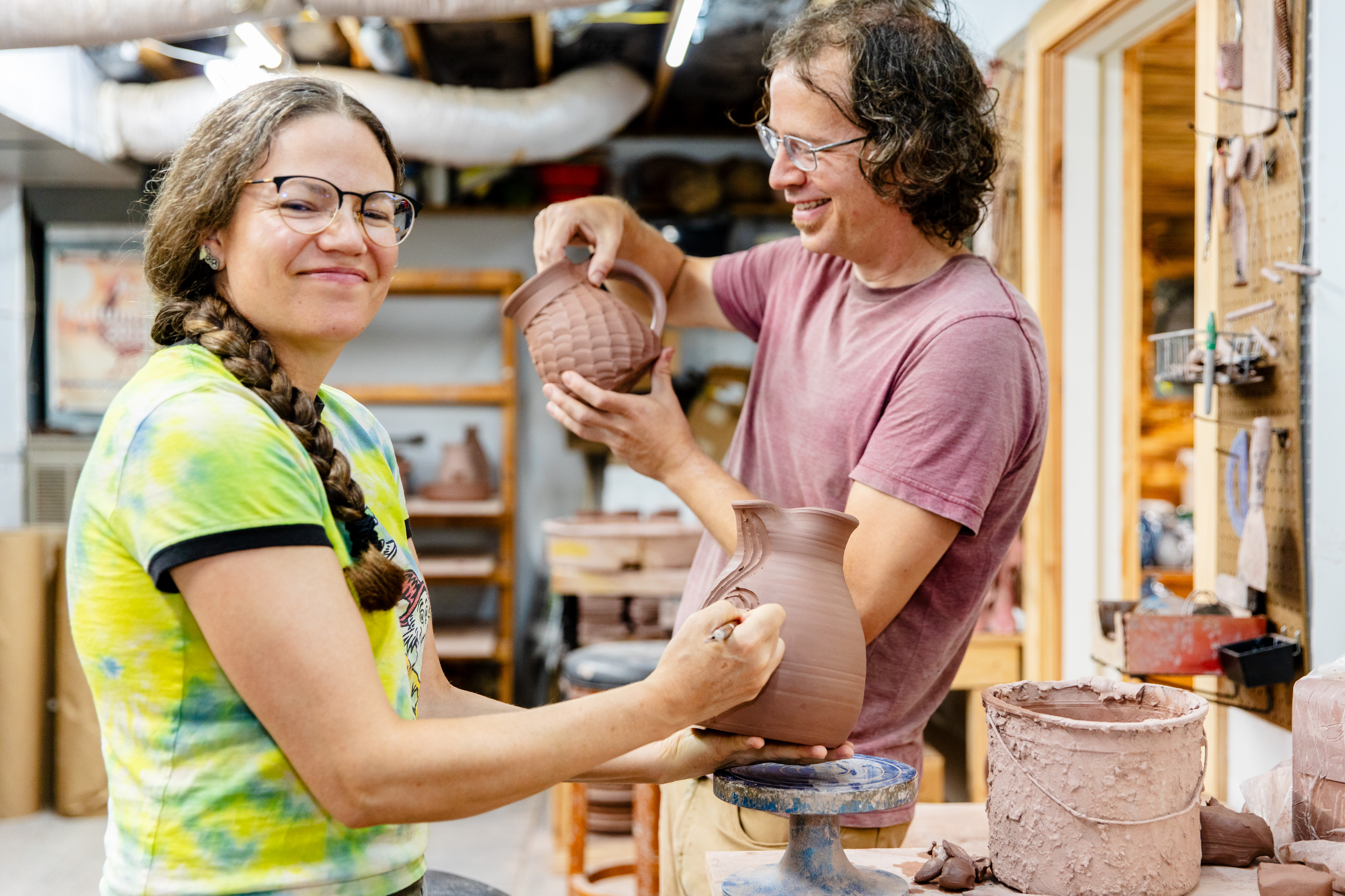 Kristin and J.R. Page work side by side to create pottery.