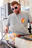 A man uses a blowpipe and heat torch while glassblowing.