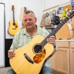 Richie Crowder holds one of his handmade guitars in his study, Crowder Guitars.