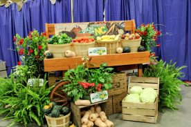 A cart overflows with vegetables and plants, symbolizing the rich agriculture of North Carolina.