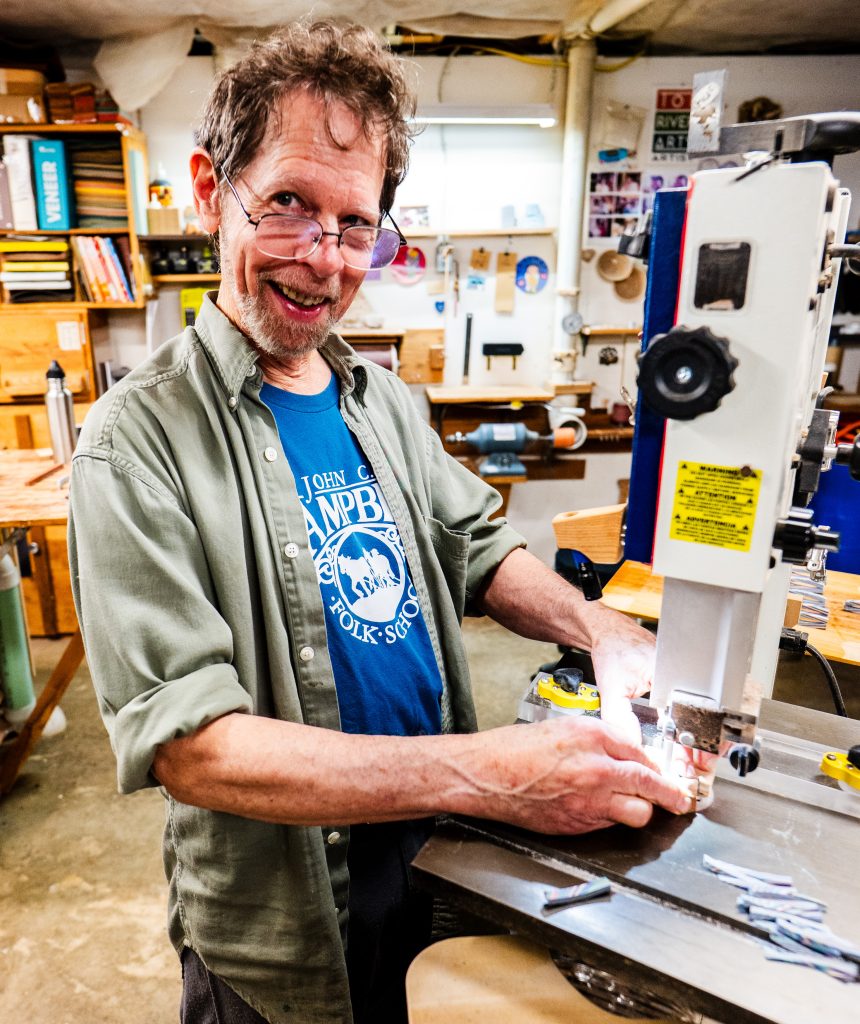 Buzz Coren creates Featherwood jewelry in his basement studio.